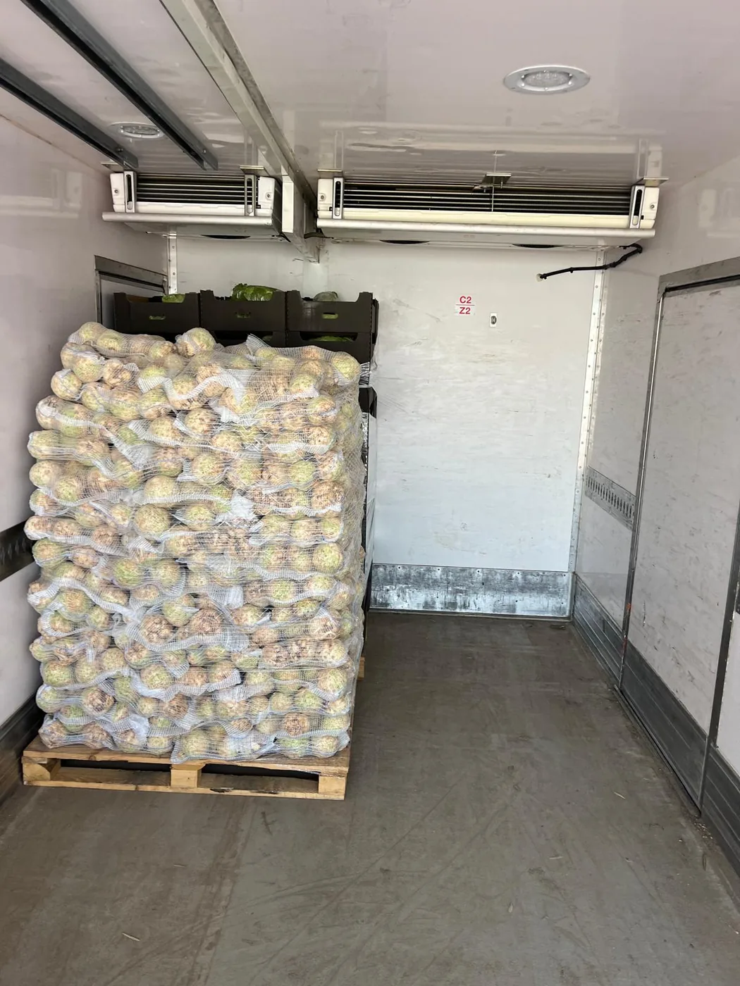 Paleta czosnku w workach siatkowych wstawiona do naczepy chłodniczej
